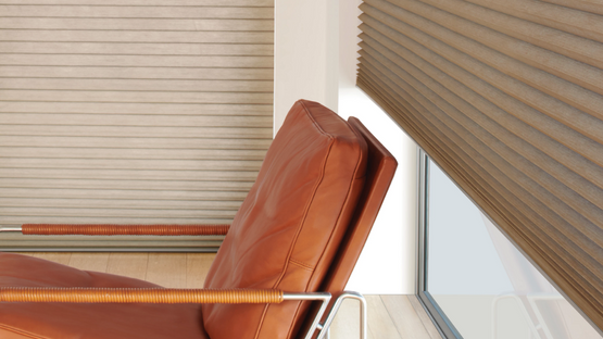 Honeycomb shades by a leather chair 25% open