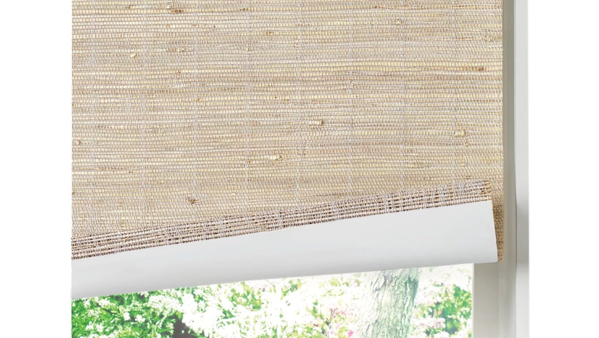 Woven wood shade with liner and bottom of shade lifted up to see white liner