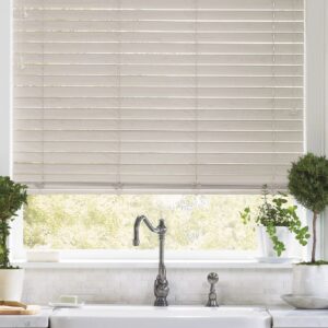 Faux woods Blinds in kitchen with skirt sink and plants on either side