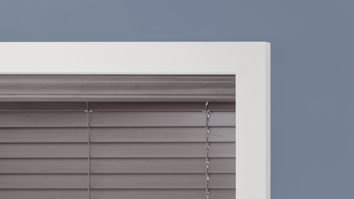 grey crown valance in white window frame with grey faux wood blinds shut