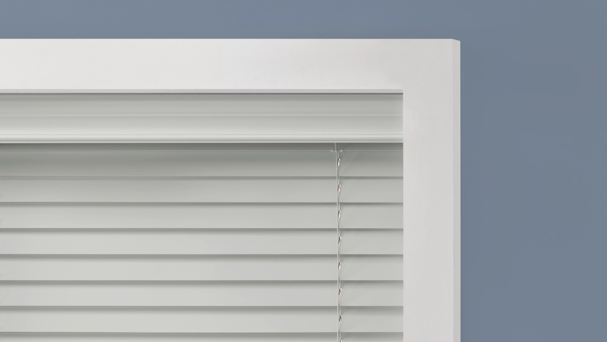 White wood blinds and valance on the inside of the window frame