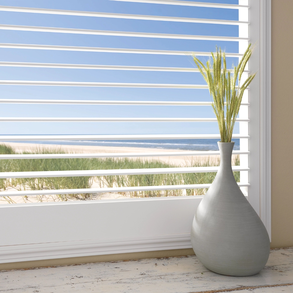 white vinyl shutters open to beach view with vase and plant