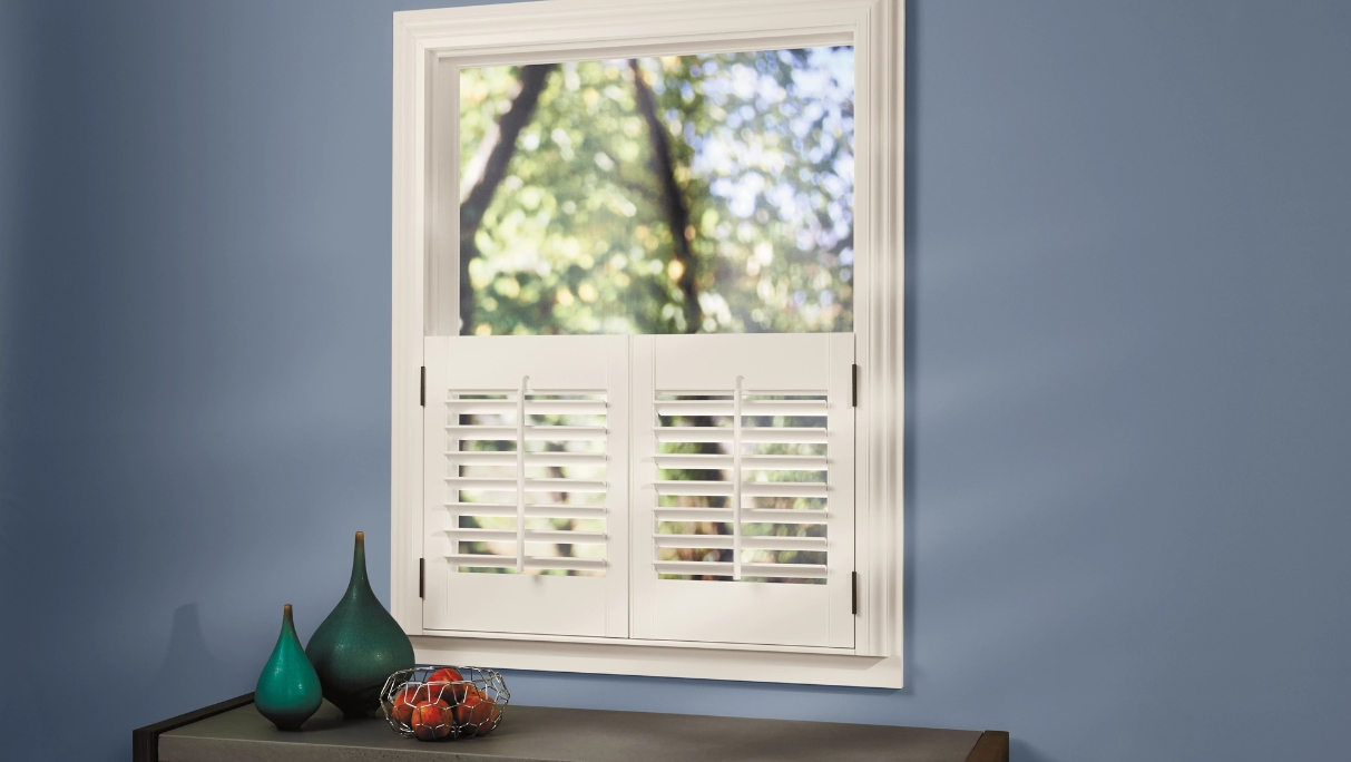 Open Half panel of white shutters on hinges closed in bottom half of window