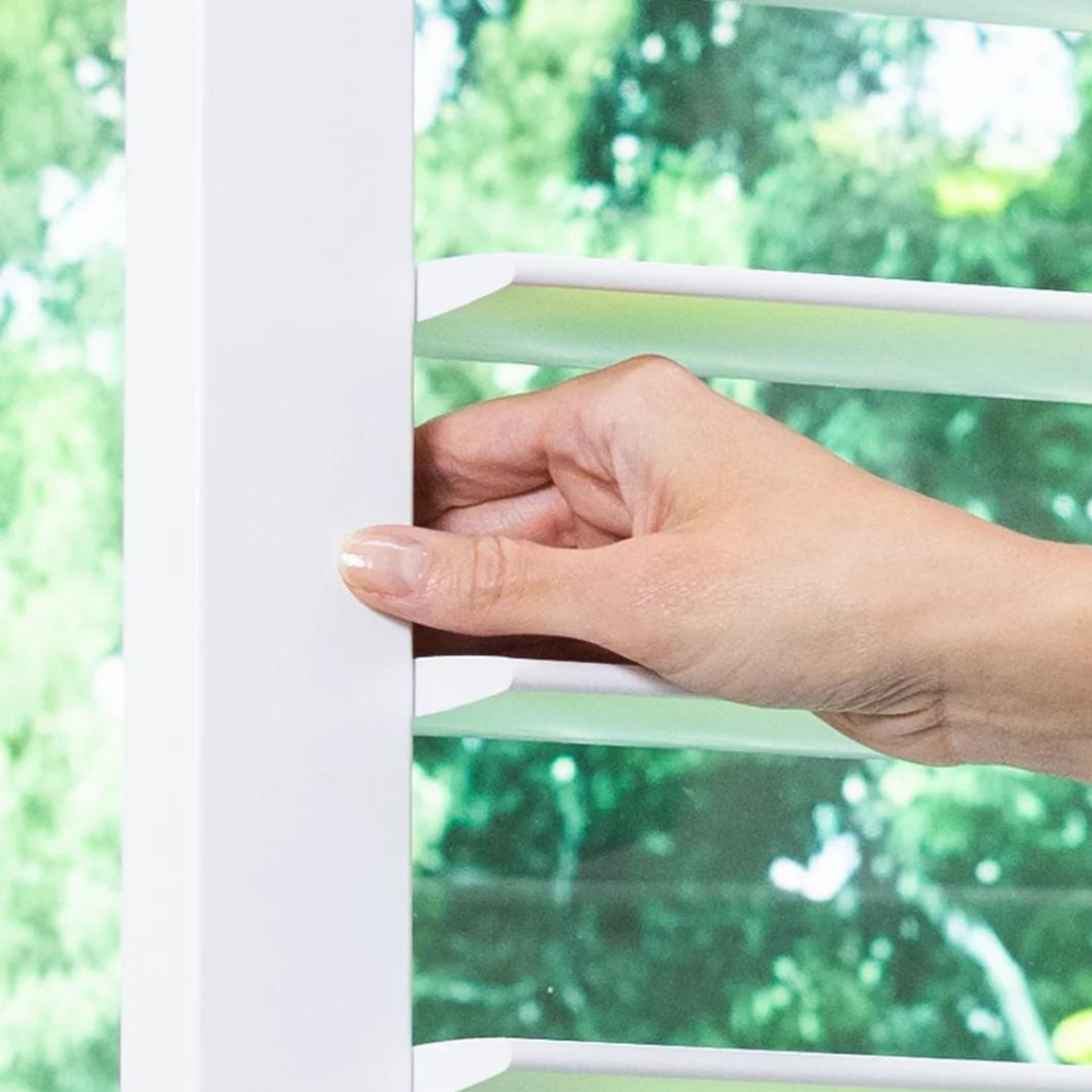 Hand between shutter louvers opening hinged shutter panels