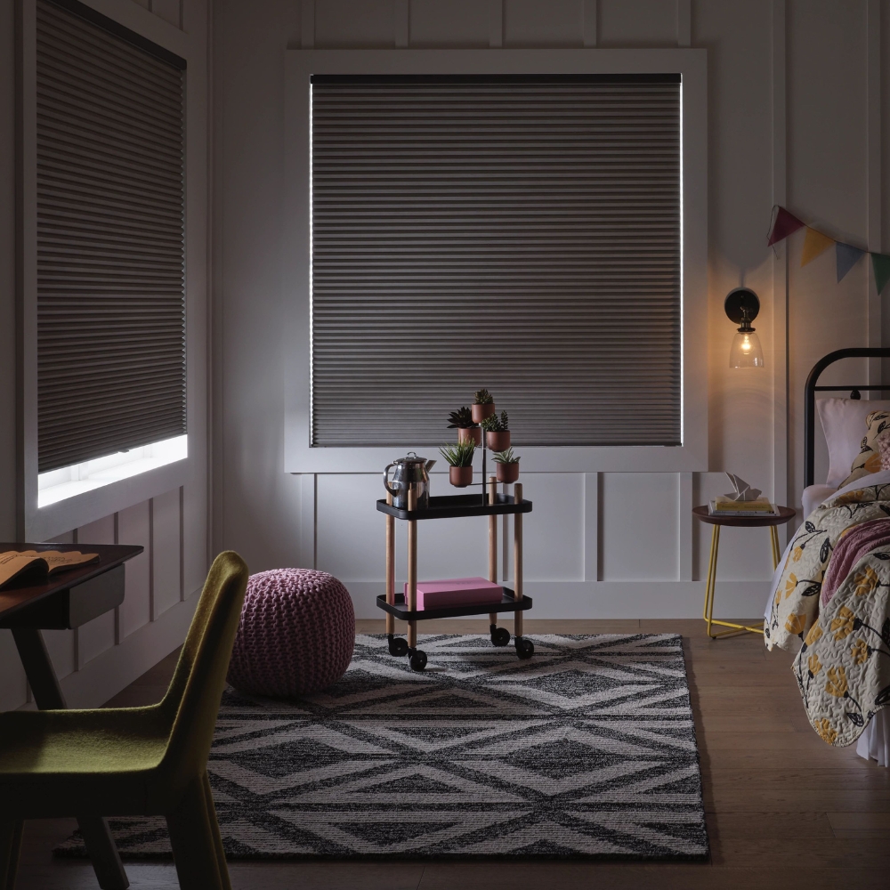 Applause Honeycomb Shades in kids room with shades closed and 1 partially open, showing room darkening