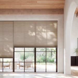 Applause Honeycomb Shades in the living room with shades half open with patio furniture outside