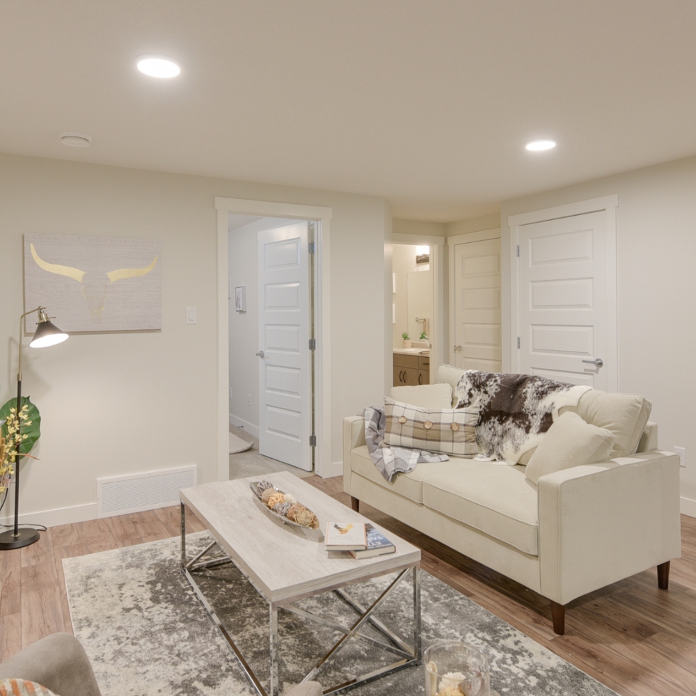 basement suite living room with high ceilings and pot lights