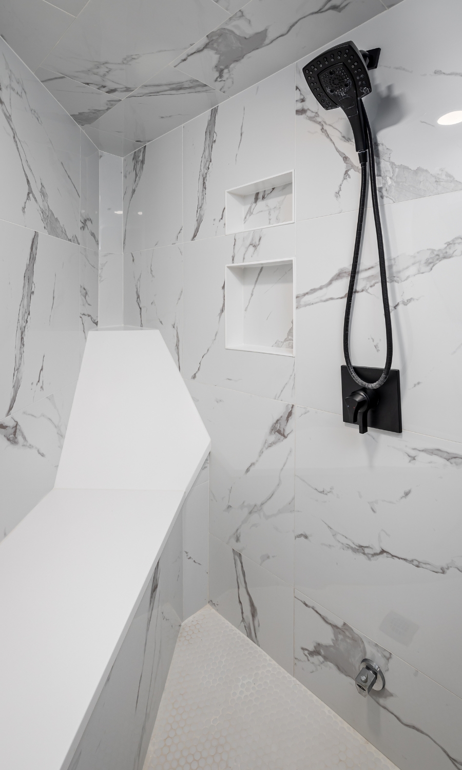 shower bench and recline in marble shower with black fixture